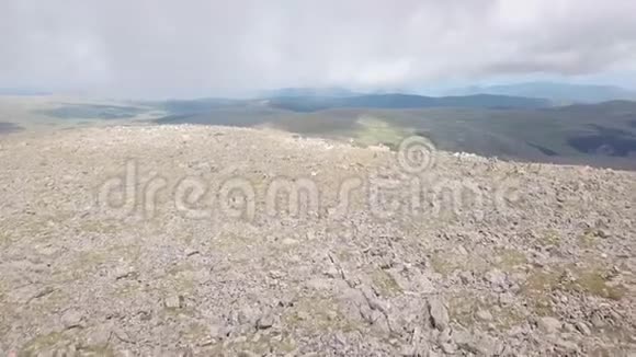 在阿尔泰山脉的夏季用大量的石头和雪冰河高空俯瞰山顶视频的预览图
