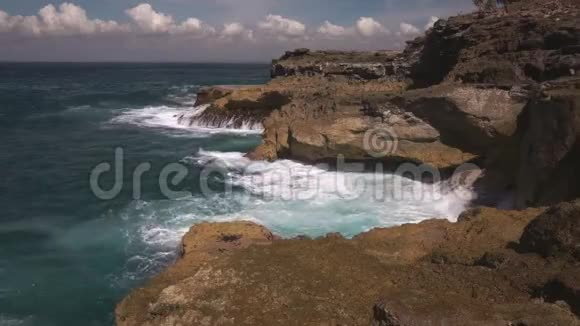 阳光明媚的一天海水在岩石上破裂视频的预览图