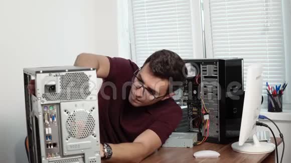 集中计算机服务人员在眼镜中修理办公室的坏电脑并升级计算机硬件视频的预览图