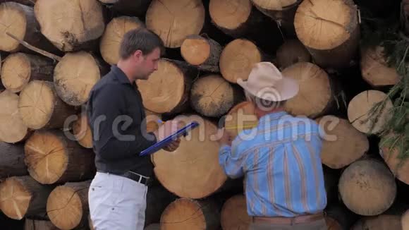 锯木厂的员工测量原木树木的末端并写下结果视频的预览图