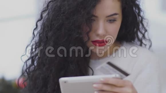 年轻女子用信用卡进行网上购物视频的预览图