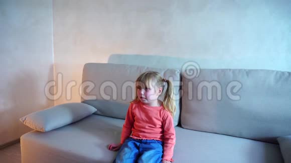 小金发美国女孩坐在沙发上哭泣视频的预览图