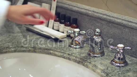 女人打开浴室水龙头用自来水洗手视频的预览图