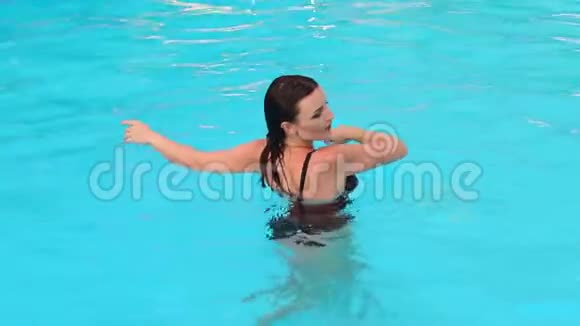 穿黑色泳衣的女孩在游泳池里游泳视频的预览图