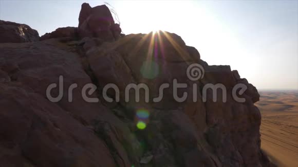 背景明亮的阳光下在炎热的沙漠中的落基山和沙丘视频的预览图