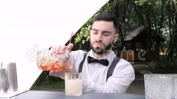 酒吧服务员将搅拌好的酒杯倒入准备好的酒杯中加入利口酒视频的预览图