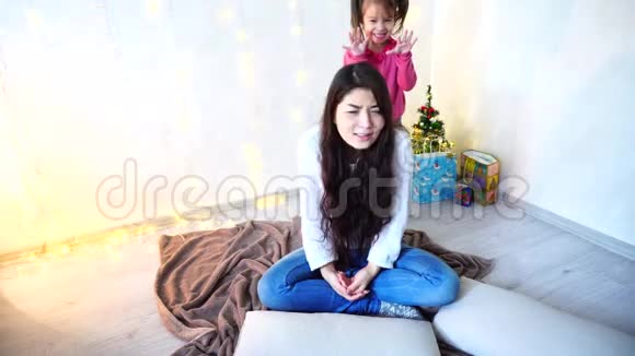 女姐姐和最小的女孩做发型坐在地板上墙上有花环和小杉视频的预览图