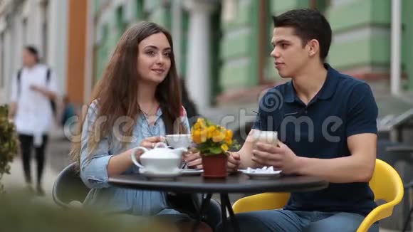 一对情侣在街头咖啡馆里一起放松视频的预览图