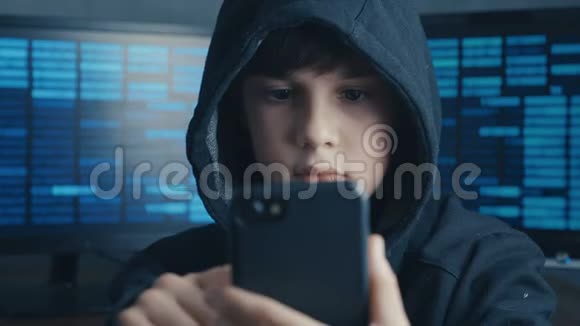 年轻的戴头罩的男孩使用智能手机设备天才少年惊奇黑客系统在网络空间的肖像视频的预览图