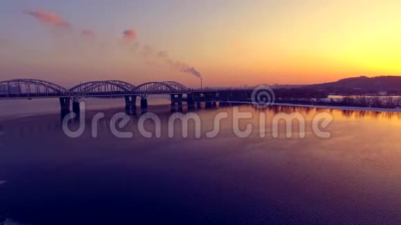 飞过江面日落时美丽的桥夕阳在水中的倒影从空中拍摄视频的预览图