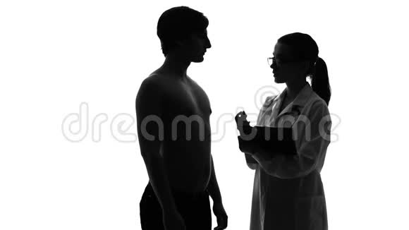 女性医生检查男性病人保健和医学的剪影视频的预览图