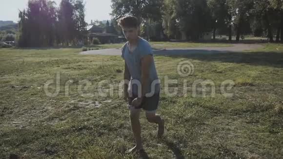 在公园里的草坪上做回飞的年轻人跑酷运动员做杂技元素视频的预览图