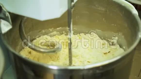 在制造过程中用专业的捏合机混合面团进行面包烘焙制作饼干视频的预览图