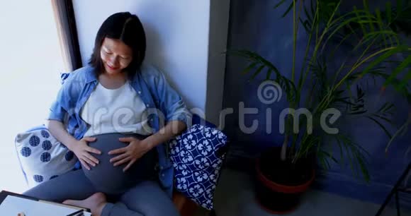 孕妇透过窗户看视频的预览图