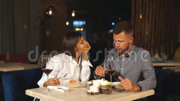 年轻夫妇在约会一个男人给他的女人吃美味的甜点一对夫妇在餐馆里笑视频的预览图