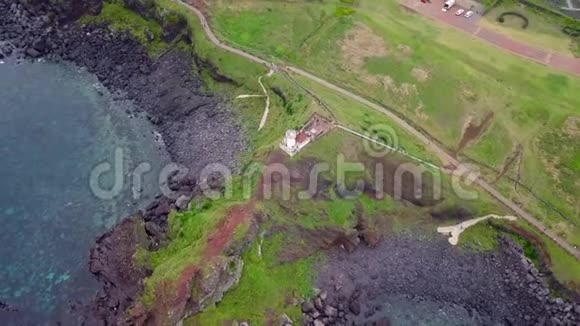 韩国济州岛火山悬崖上灯塔的鸟瞰图视频的预览图