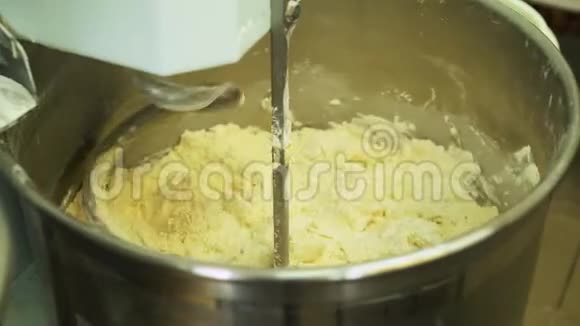 在制造过程中用专业的捏合机混合面团进行面包烘焙制作饼干视频的预览图