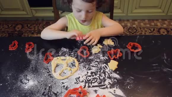 小可爱的女孩做肉桂姜饼饼干圣诞节和2019年新年的概念红色塑料造型黄色礼服视频的预览图