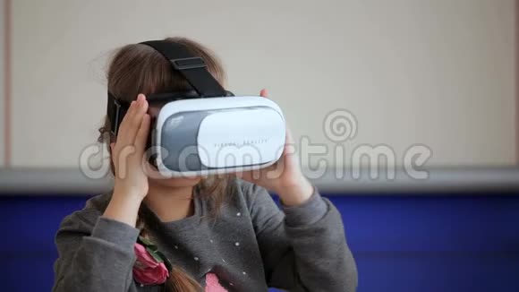 戴着虚拟现实面具的年轻女孩环顾四周视频的预览图