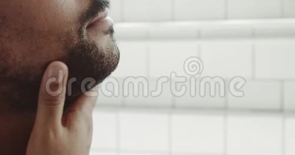 混血男人刮胡子前摸了摸他的脸和胡子视频的预览图