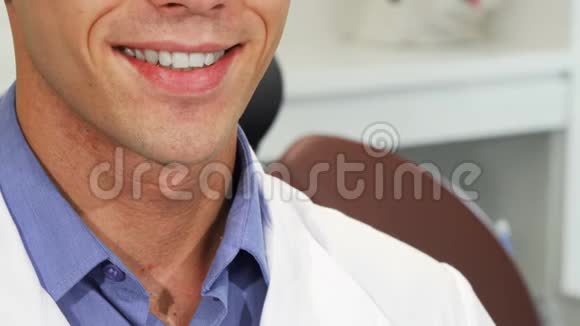 男牙科医生笑着用完美的牙齿拿着牙刷视频的预览图