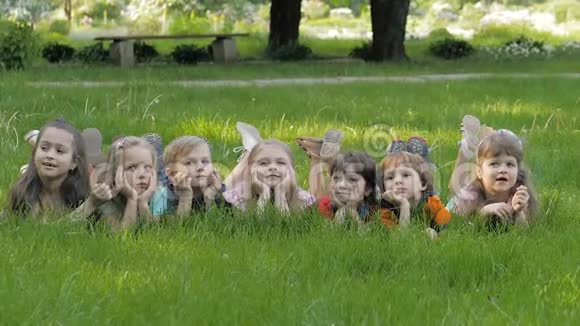 春天公园里一群快乐的孩子躺在草地上视频的预览图