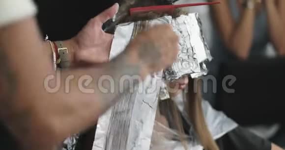 理发师用刷子和铝箔把油漆涂在头发上视频的预览图