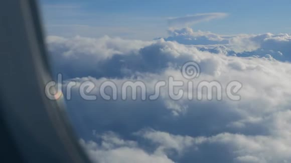 蓝天上的白色大堆云透过飞机舷窗视频的预览图