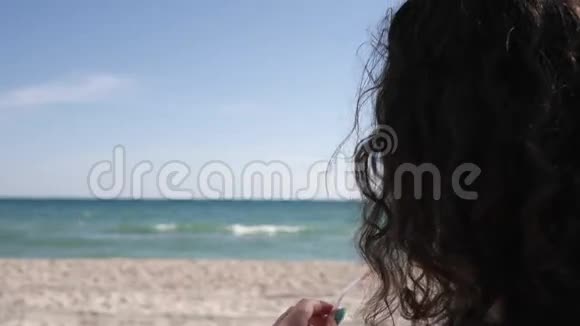 女伴手拿着热带海滩上的鸡尾酒女孩戴着太阳镜在海边喝果汁好女人从视频的预览图