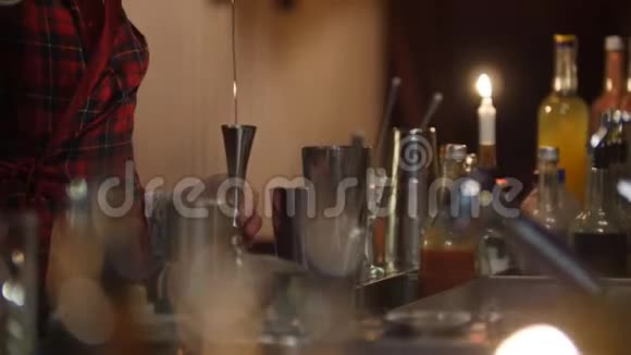 年轻的职业酒保倒伏特加在杯子里混合伏特加视频的预览图