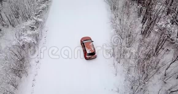 冬天有一辆车可以鸟瞰白雪森林和道路视频的预览图