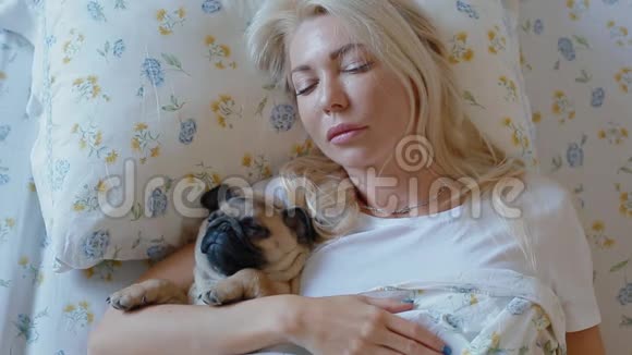 拥抱躺在床上的小狗狗的女人视频的预览图