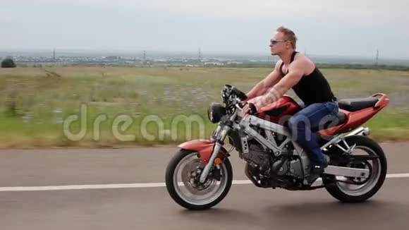 英俊的男人骑着摩托车在路上视频的预览图
