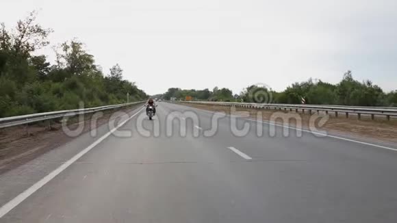 英俊的男人骑着摩托车在路上视频的预览图