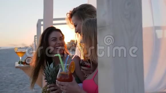 女伴微笑在背景上喝彩色鸡尾酒视频的预览图