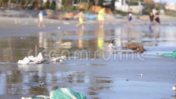 在被垃圾垃圾污染的海滩上玩耍儿童的静态镜头视频的预览图