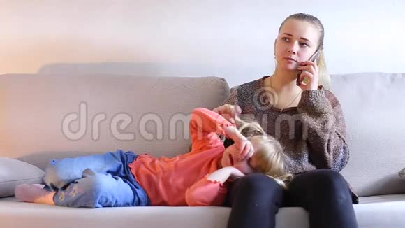 年轻的欧洲女人坐在沙发上打电话视频的预览图