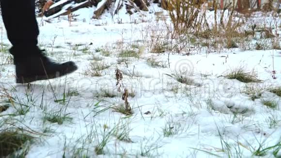 一个穿着黑色靴子在夕阳下的雪地里行走的人的腿视频的预览图