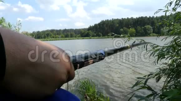 人手握鱼竿临湖垂钓视频的预览图
