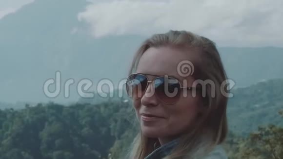 幸福的女人越过山景背景的肖像视频的预览图