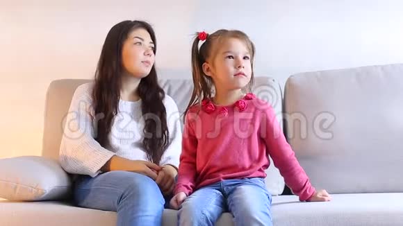 妈妈和小女儿坐在沙发上孩子尖叫女人站起来走开视频的预览图