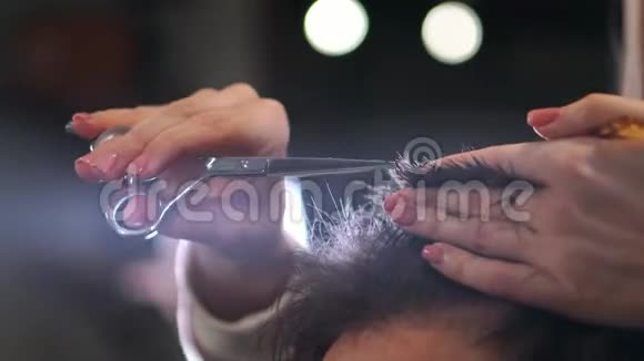 特写主理发师用剪刀和梳子做发型和风格概念理发店视频的预览图
