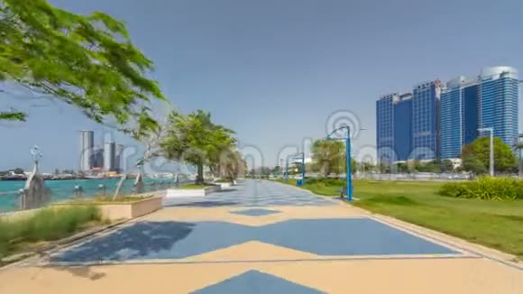 科尼切大道海滩公园沿着阿布扎比海岸线的时间推移超垂背景是摩天大楼视频的预览图