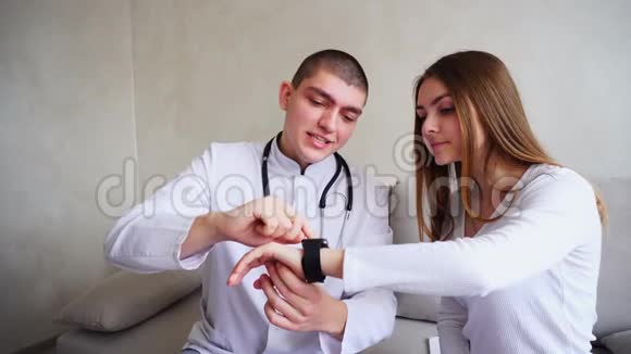 智能男医生的画像她向病人解释如何使用智能手表来监测他们的健康和健康视频的预览图