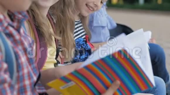 可爱的孩子在长椅上用书和笔记本学习视频的预览图