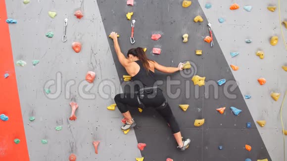 在室内人工墙上练习攀岩的妇女积极的生活方式和抱石理念视频的预览图