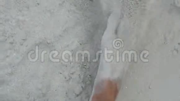 一个人带着白色沙子在沙滩上行走的腿视频的预览图