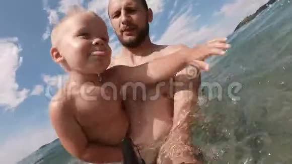 快乐的父亲和儿子一起在海滩上自拍视频的预览图