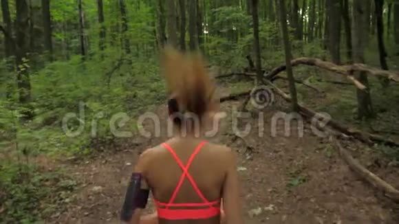 有长发的运动妇女在森林跑道上跑步运动和娱乐视频的预览图