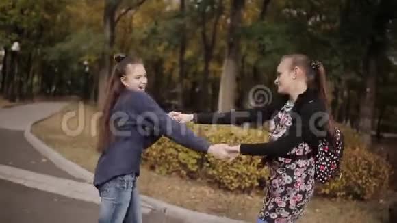 两个快乐的朋友骑着电子滑板车在秋天的公园里跳舞视频的预览图